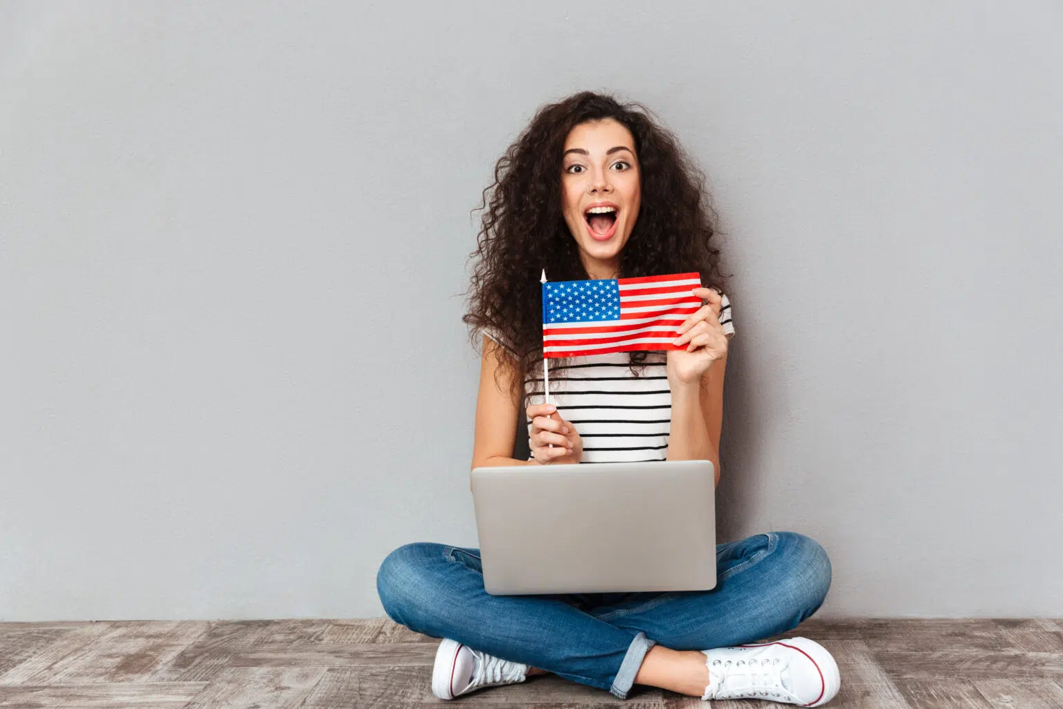 Smiling professional with laptop and American flag backdrop